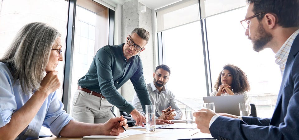 Mehrere Personen an einem Koferenztisch während eines Meetings