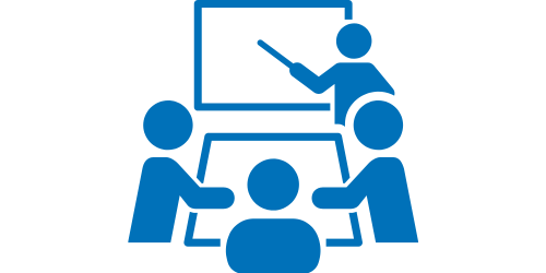 Blaues Icon von einer Person vor einer Tafel die mit einem Zeigestock darauf zeigt. Davor ist ein Tisch an dem 3 weitere Personen sitzen